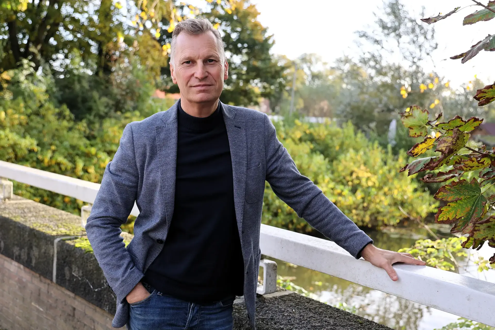Remko Kamstra staat op een brug met op de achtergrond bomen en struiken.